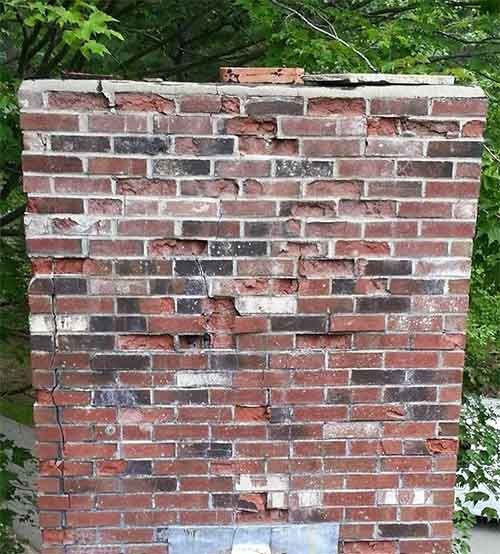 Masonry damage brick facing falling off cracks no tuckpointing trees in background