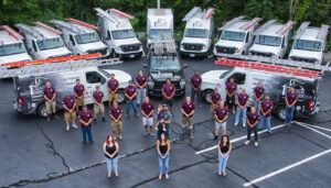 Team Photo with logo t-shirts and a fleet of vans