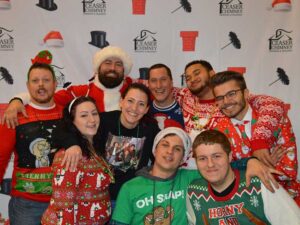 Team Photo 2 women 7 men in ugly Christmas sweaters