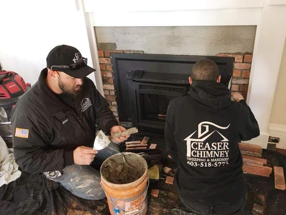 Original picture of Ceaser Chimney crew members installing a fireplace insert.